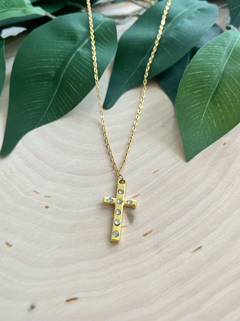 Gold cross pendant necklace with small stud accents, on thin chain