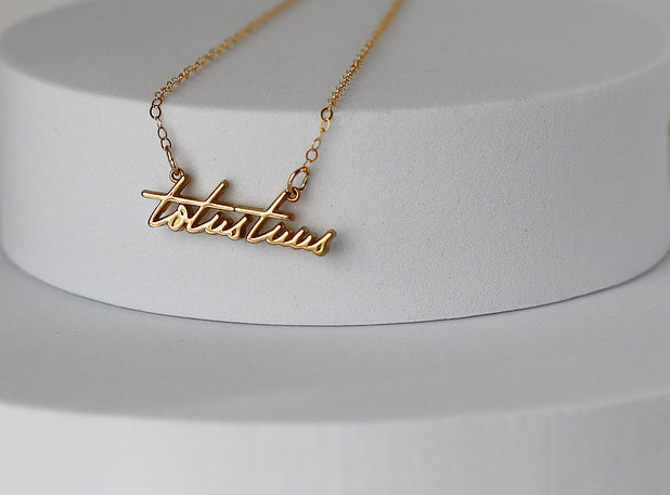 Gold-tone script pendant necklace with linked chain