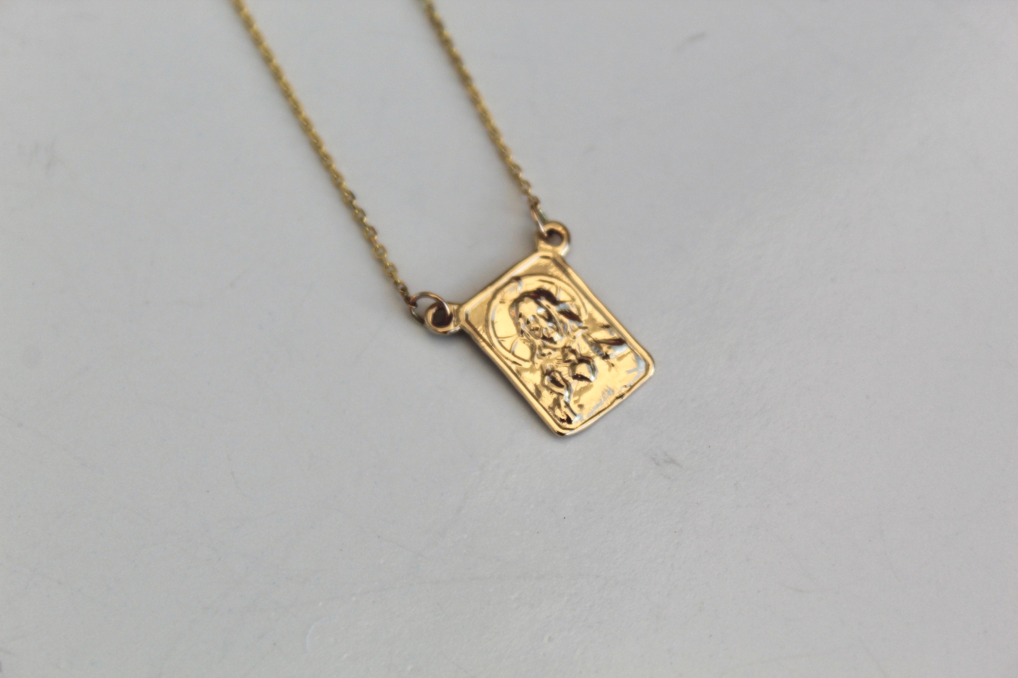 Gold scapular pendant on a fine chain, square with embossed figure design
