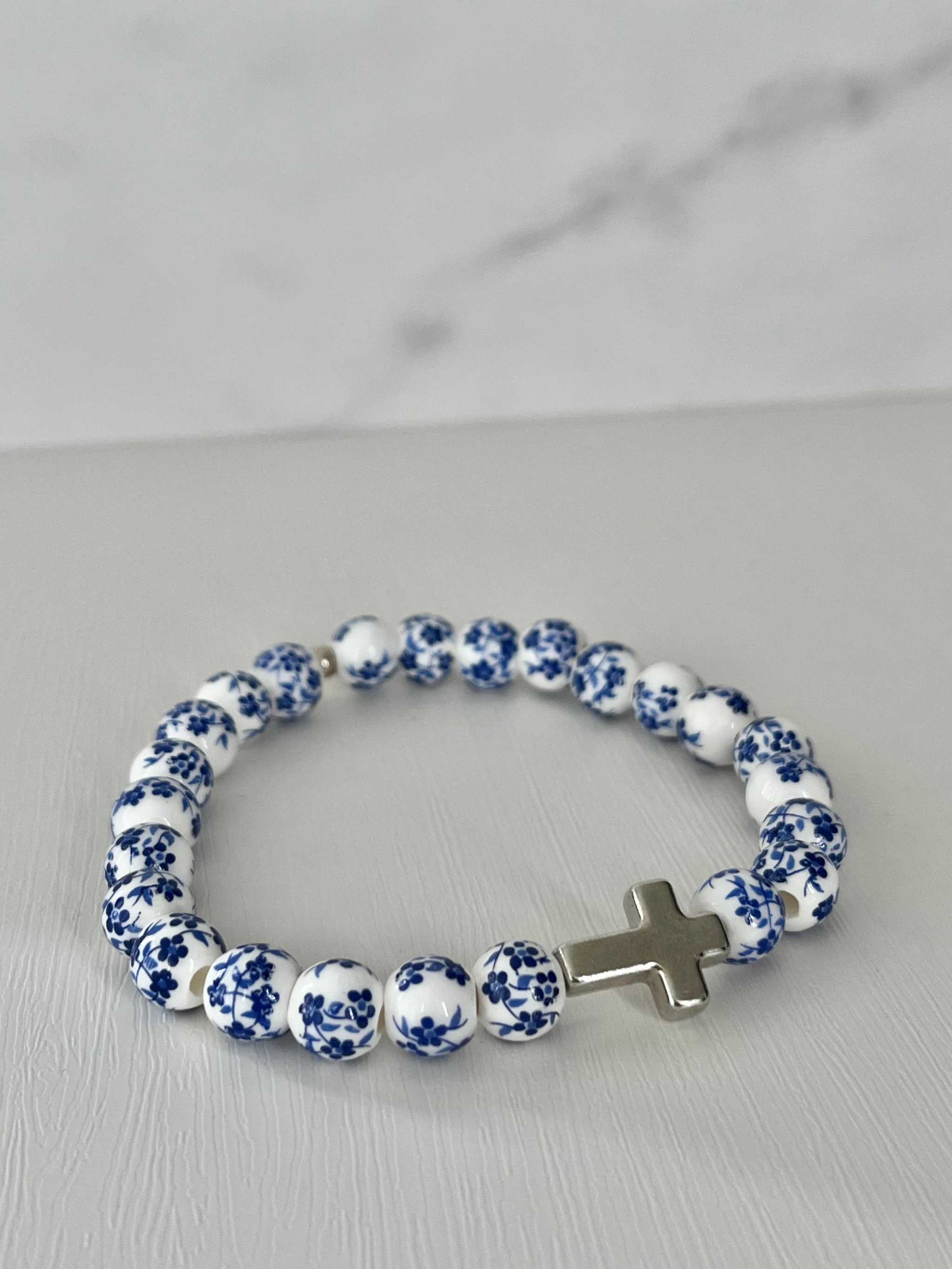 Beaded cross bracelet with blue-and-white patterned beads and rhinestone cross charm