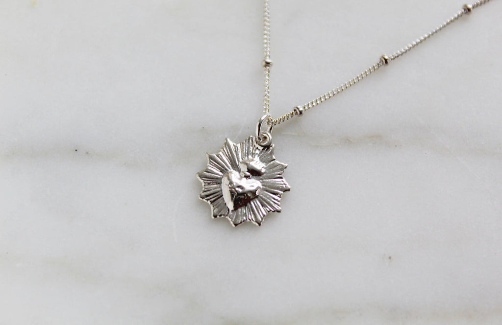 Sterling silver heart pendant necklace with scalloped details on a chain