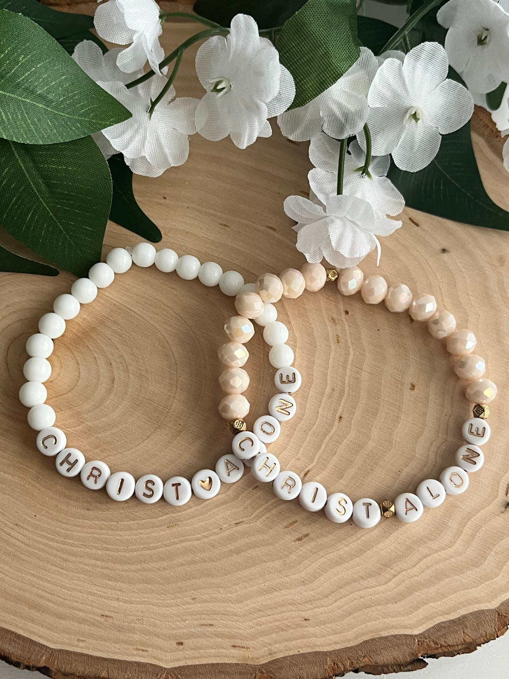 White bead bracelet with round letter beads spelling "CHRIST ALONE"