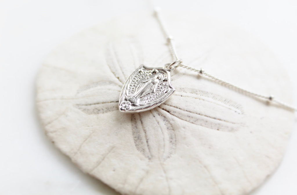 Sterling silver shield pendant necklace with Virgin Mary figure, delicate chain