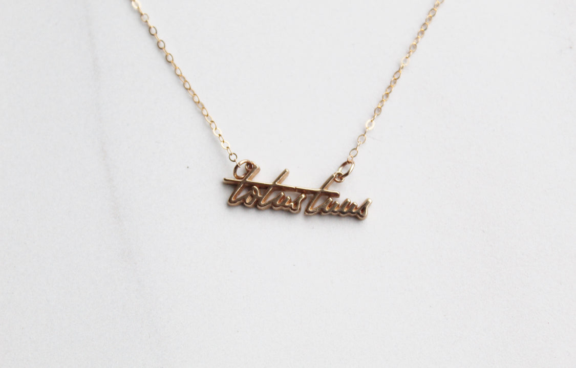 Gold-tone Totus Tuus script pendant necklace close-up