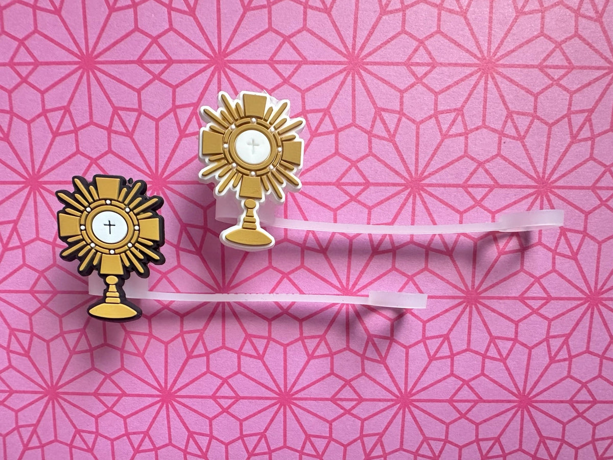 Two gold Adoration straw toppers with cross and chalice emblems