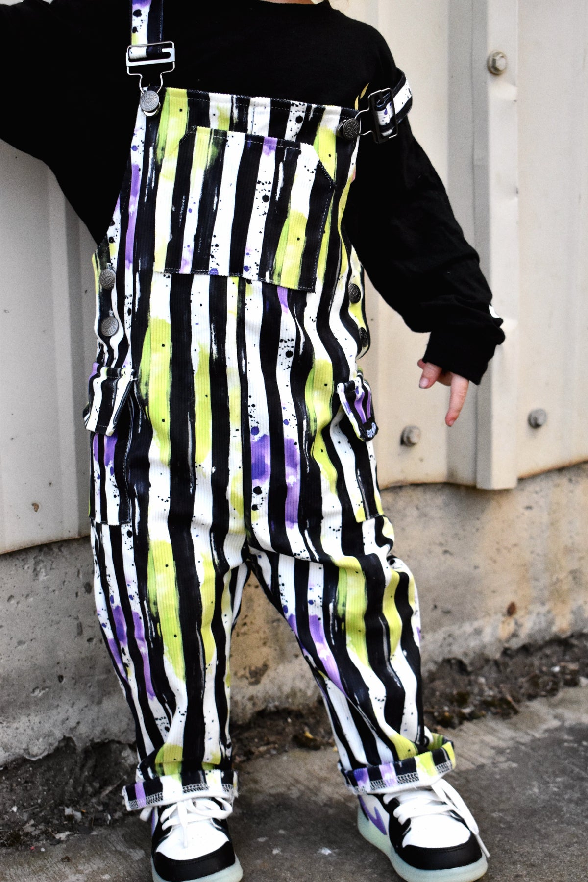 Kids Halloween overalls close-up with black bib, striped legs, and metal strap buckles