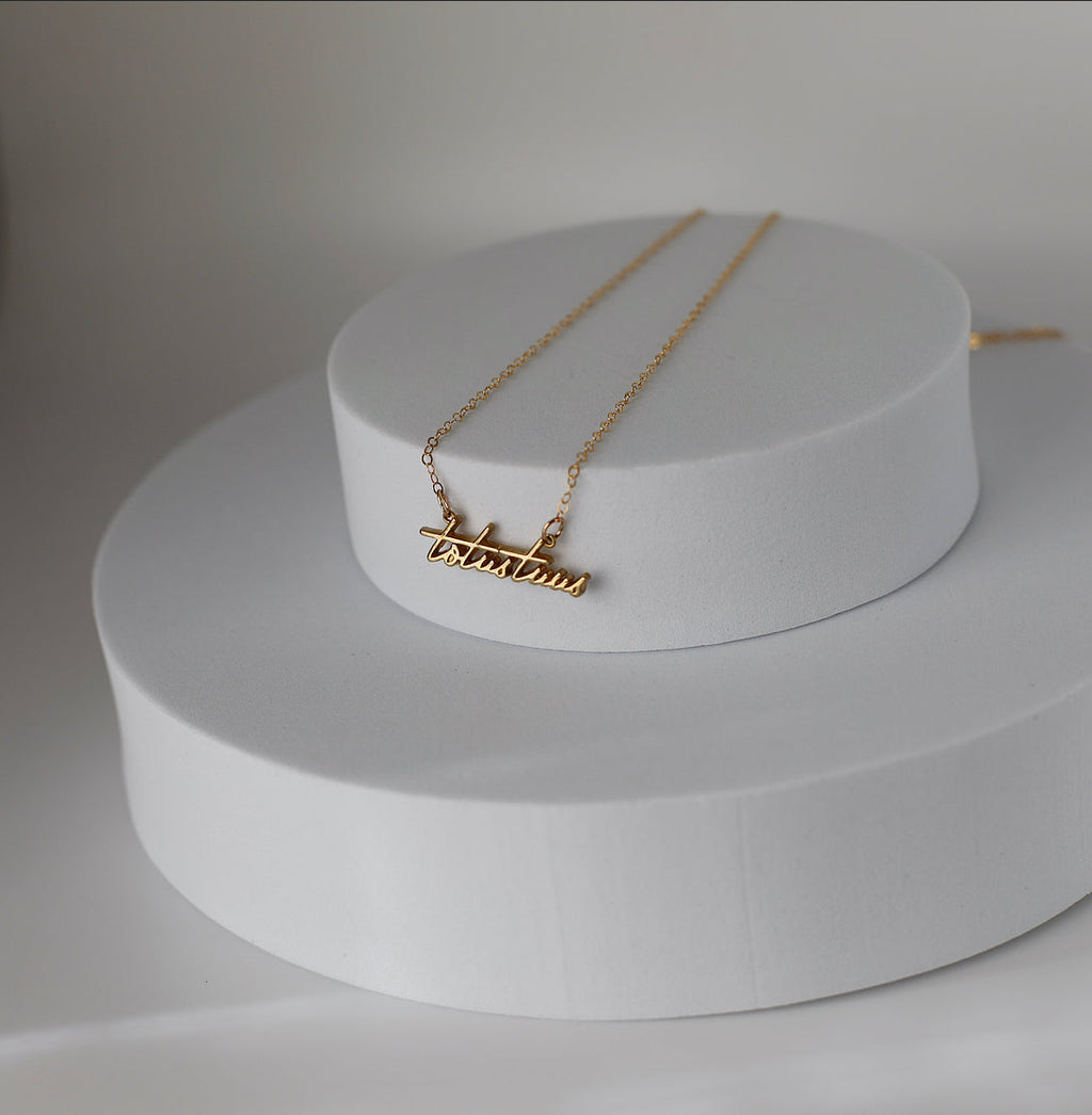 Gold-tone script pendant necklace with cross bar charm