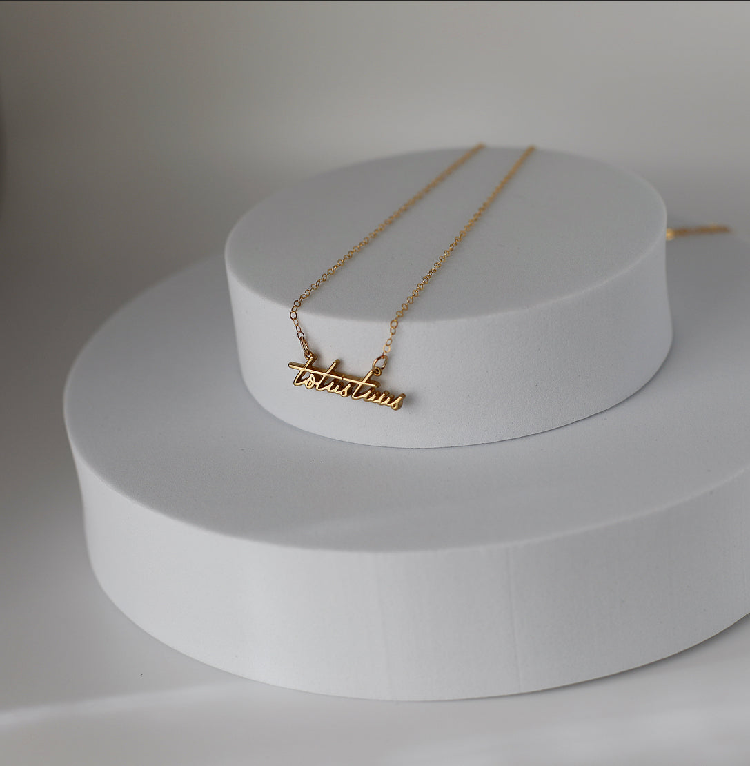 Gold-tone script pendant necklace with cross bar charm