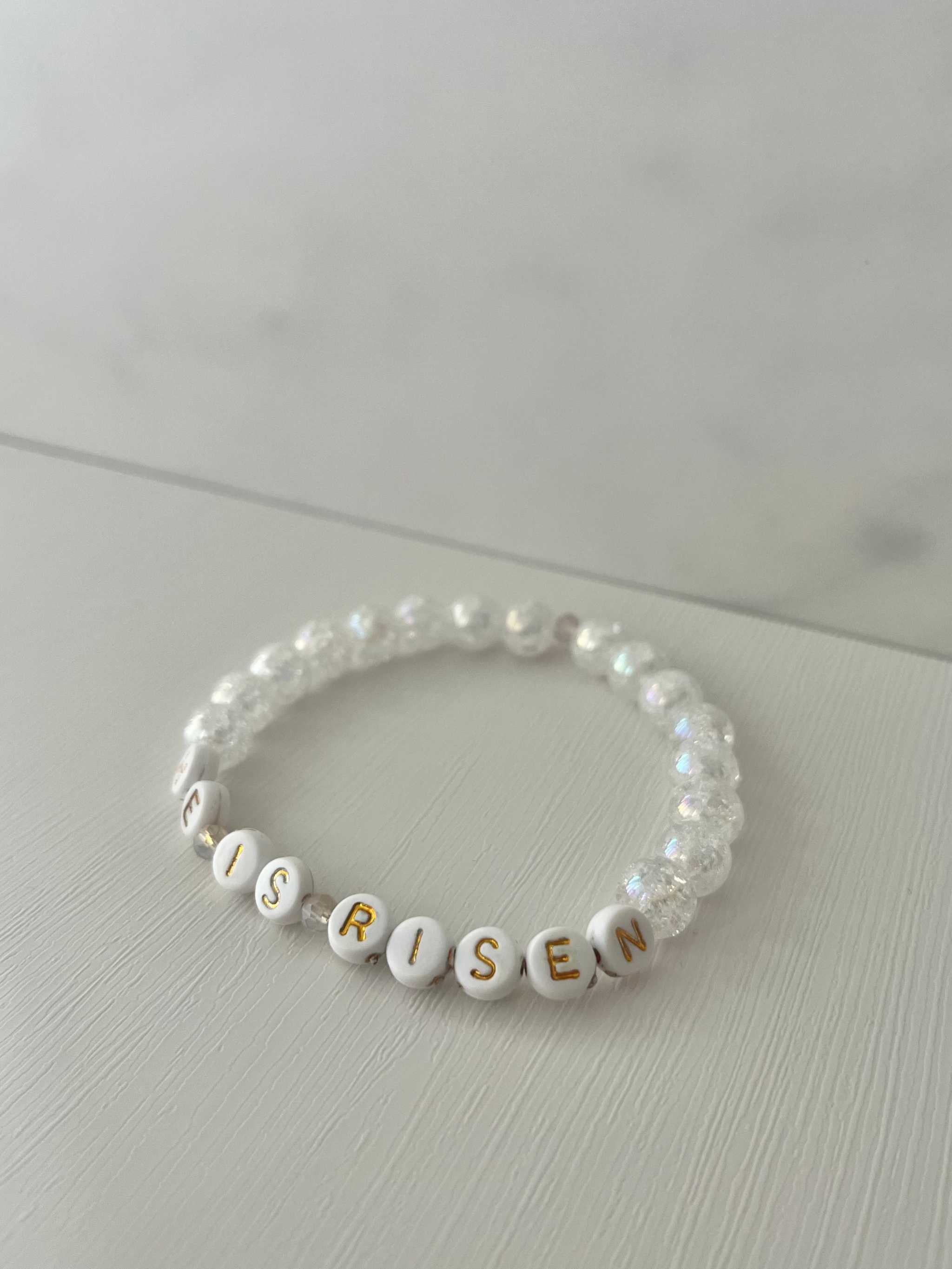 White bead bracelet with 'HE IS RISEN' letter beads and clear round accents