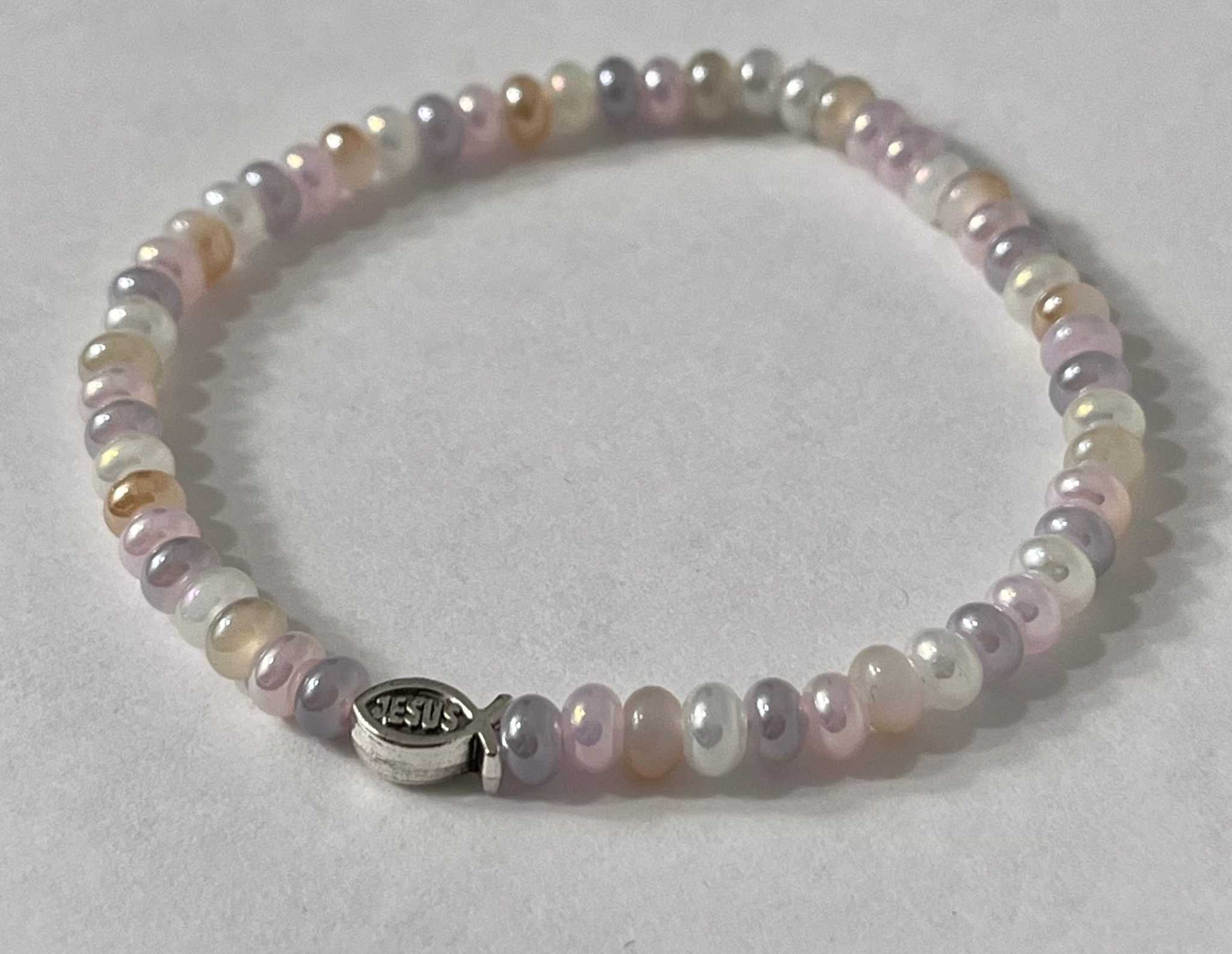 Bead bracelet with pastel purple, white, and peach beads and a silver Jesus charm
