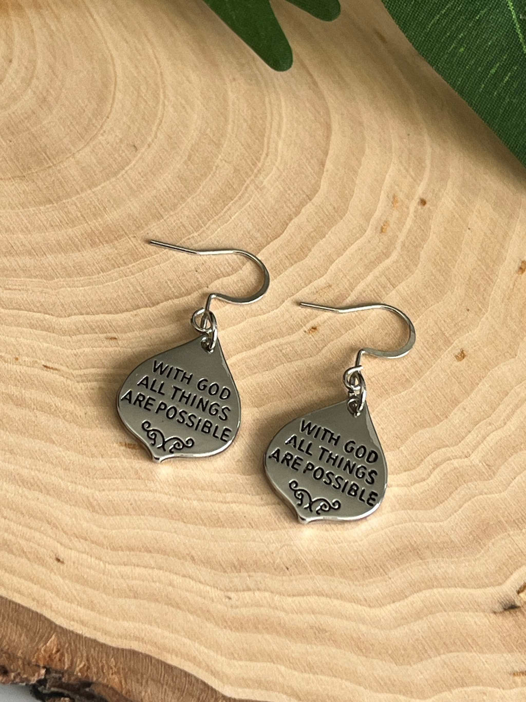 Silver dangle earrings with “With God all things are possible” engraved on round charms.