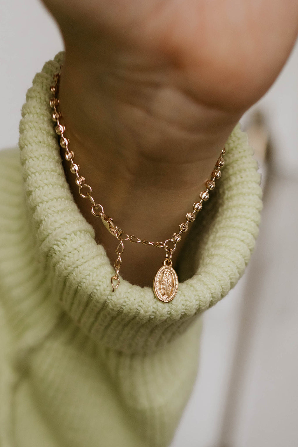Gold-tone chain bracelet with oval medal pendant and small link details