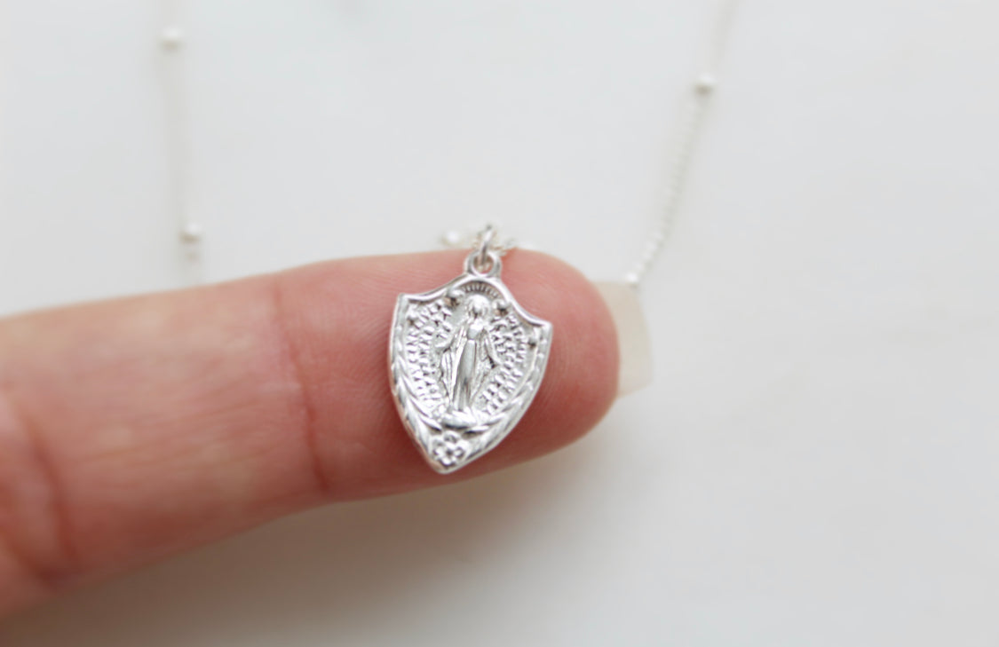 Sterling silver shield pendant with Virgin Mary figure on cable chain, front view