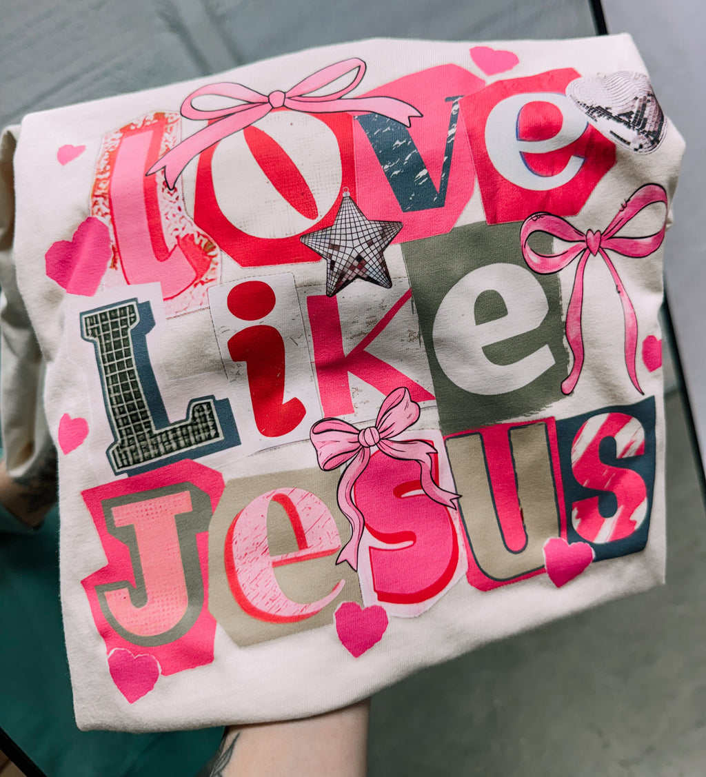 Cream short-sleeve graphic T-shirt with 'Love Like Jesus' text and heart icons