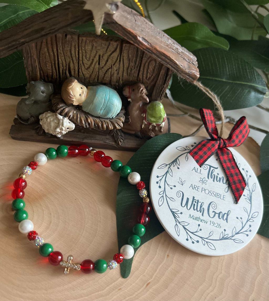 Beaded bracelet with red, green, and white beads and a small silver cross charm