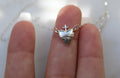 Sterling silver heart pendant and small cross on chain, held in fingers