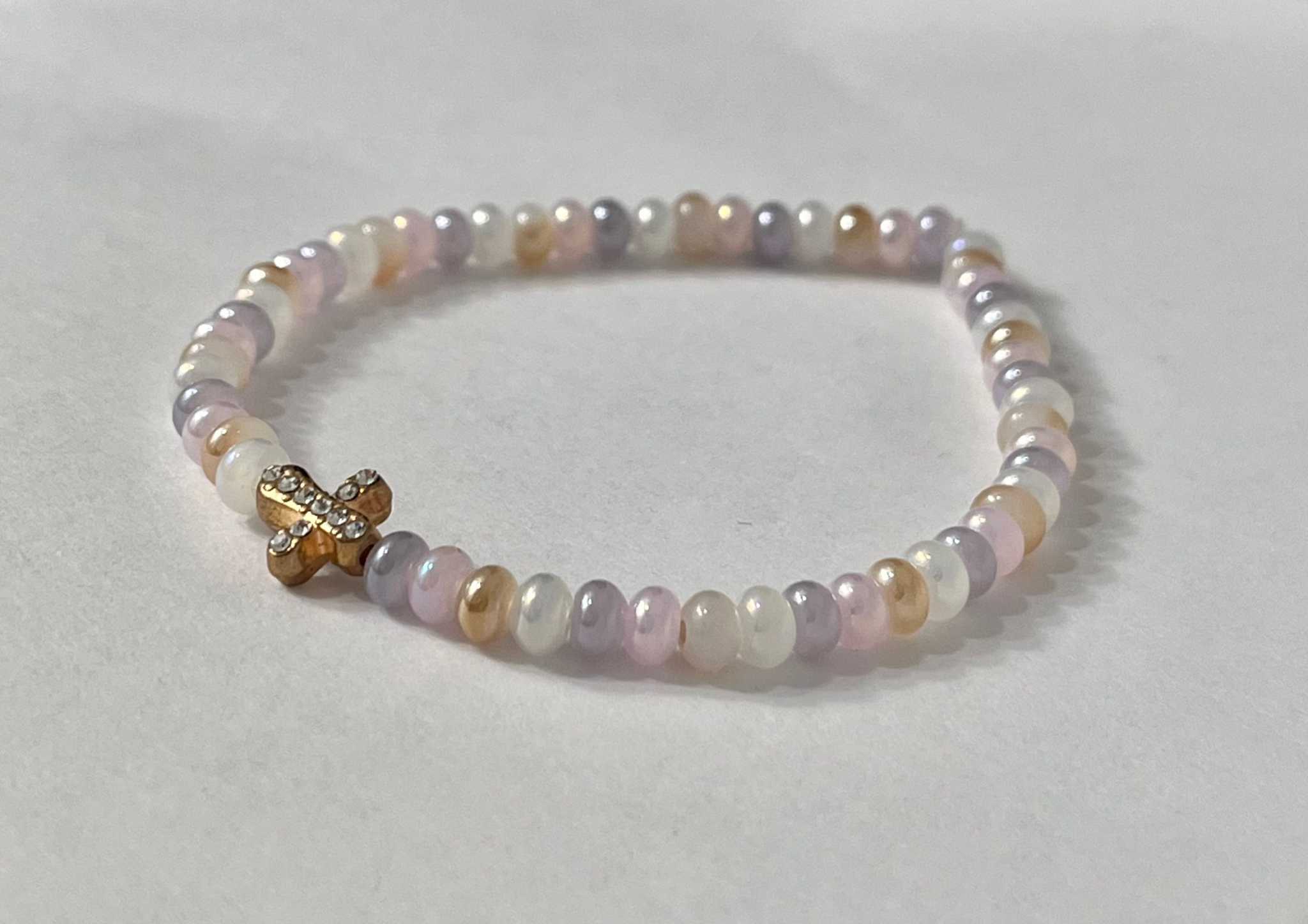 Bead bracelet with pearl-like beads in pale pink and white and a gold cross charm