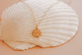 Gold pendant necklace with small round coin-style Holy Spirit charm on chain