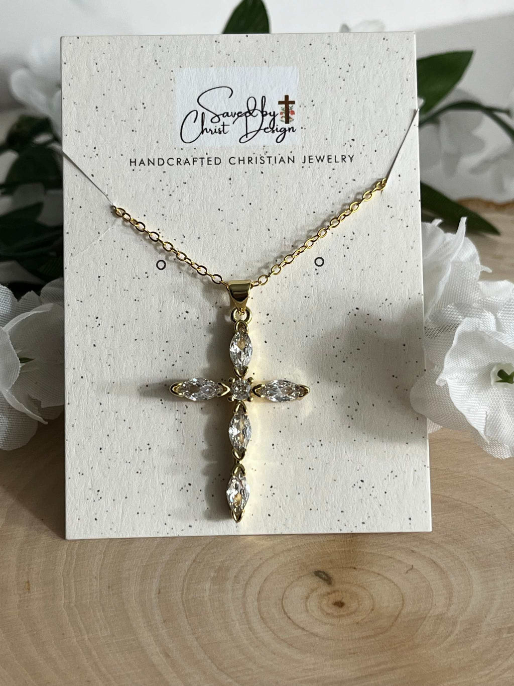 Gold cross pendant necklace with clear crystal stones and a small chain bail