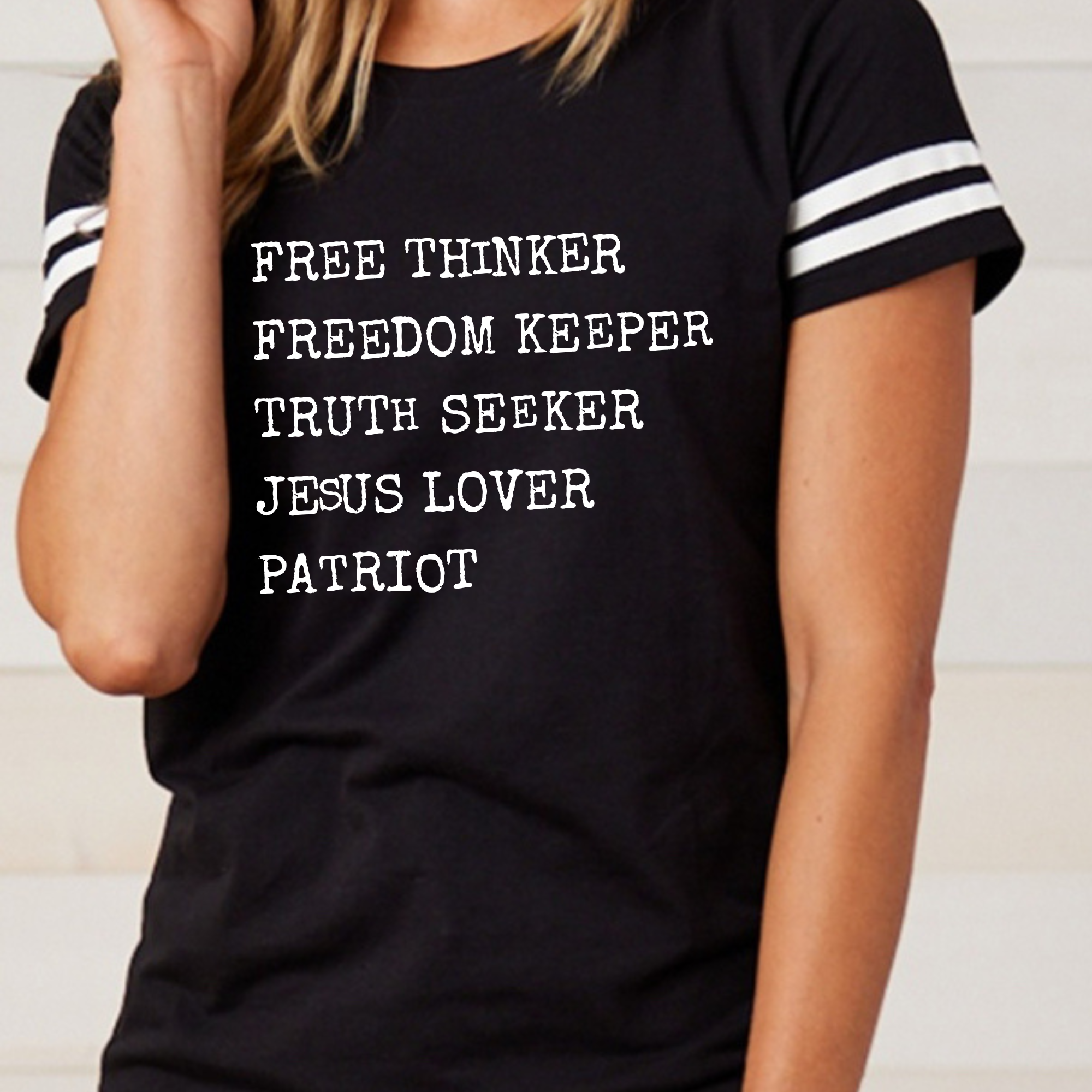 Black crewneck graphic T-shirt with striped sleeves and FREE THINKER text