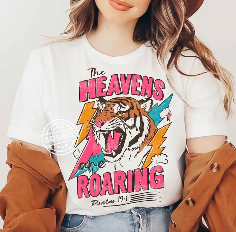 White tee with roaring tiger graphic, 'Heavens Roaring' text, Psalm 19:1