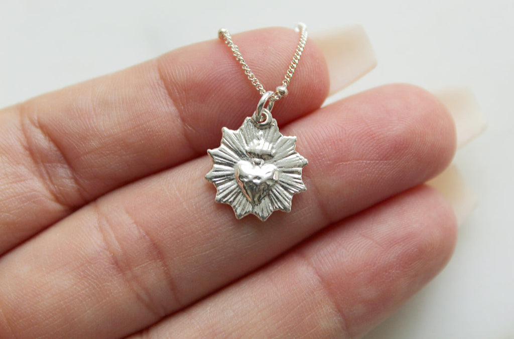 Sterling silver heart pendant with scalloped edges on a delicate chain