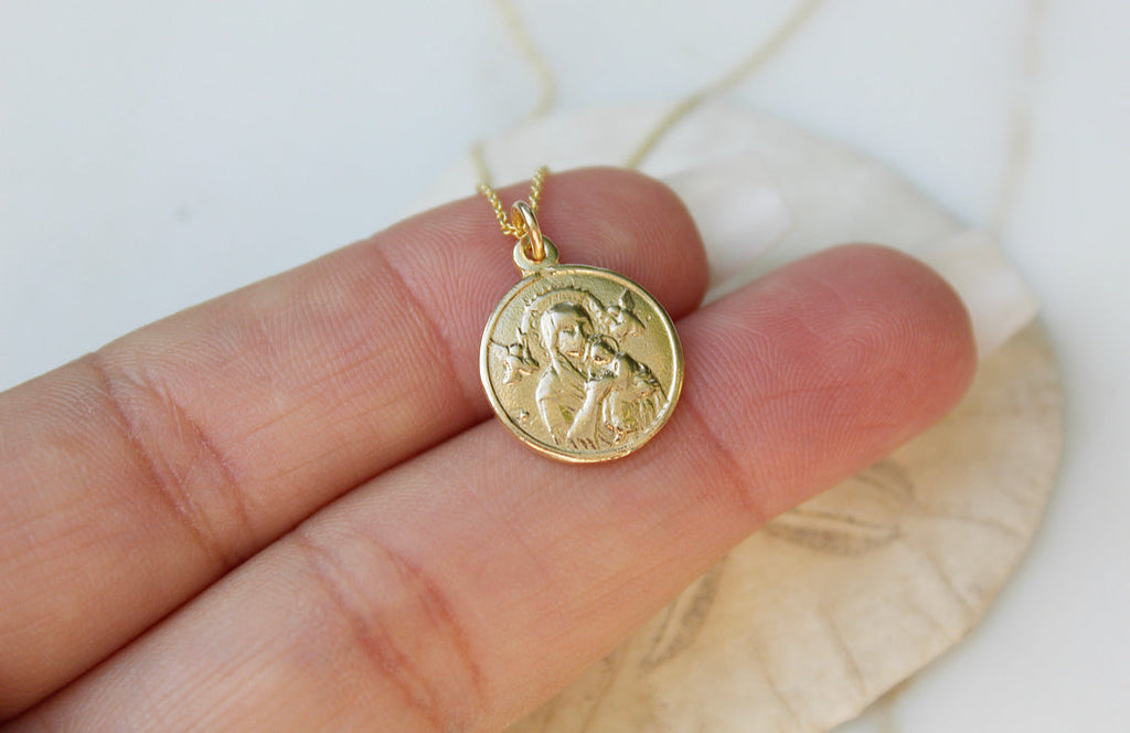 14k gold pendant necklace with round medallion featuring Our Lady relief