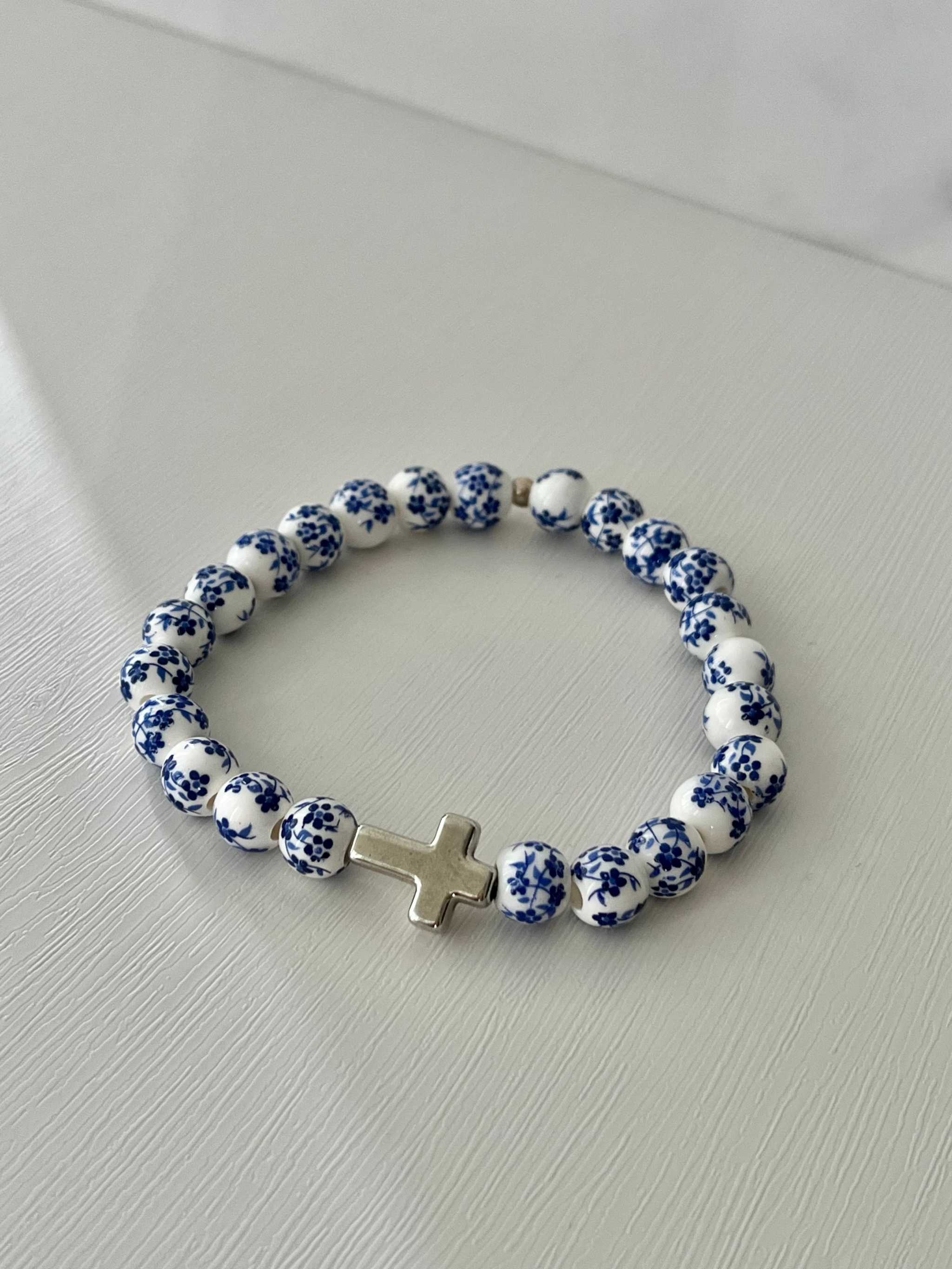 Beaded cross bracelet with blue speckled round beads and metal rhinestone cross