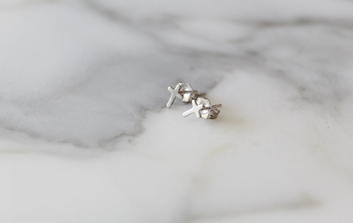 Sterling silver cross stud earrings set, two crosses on backing surface.