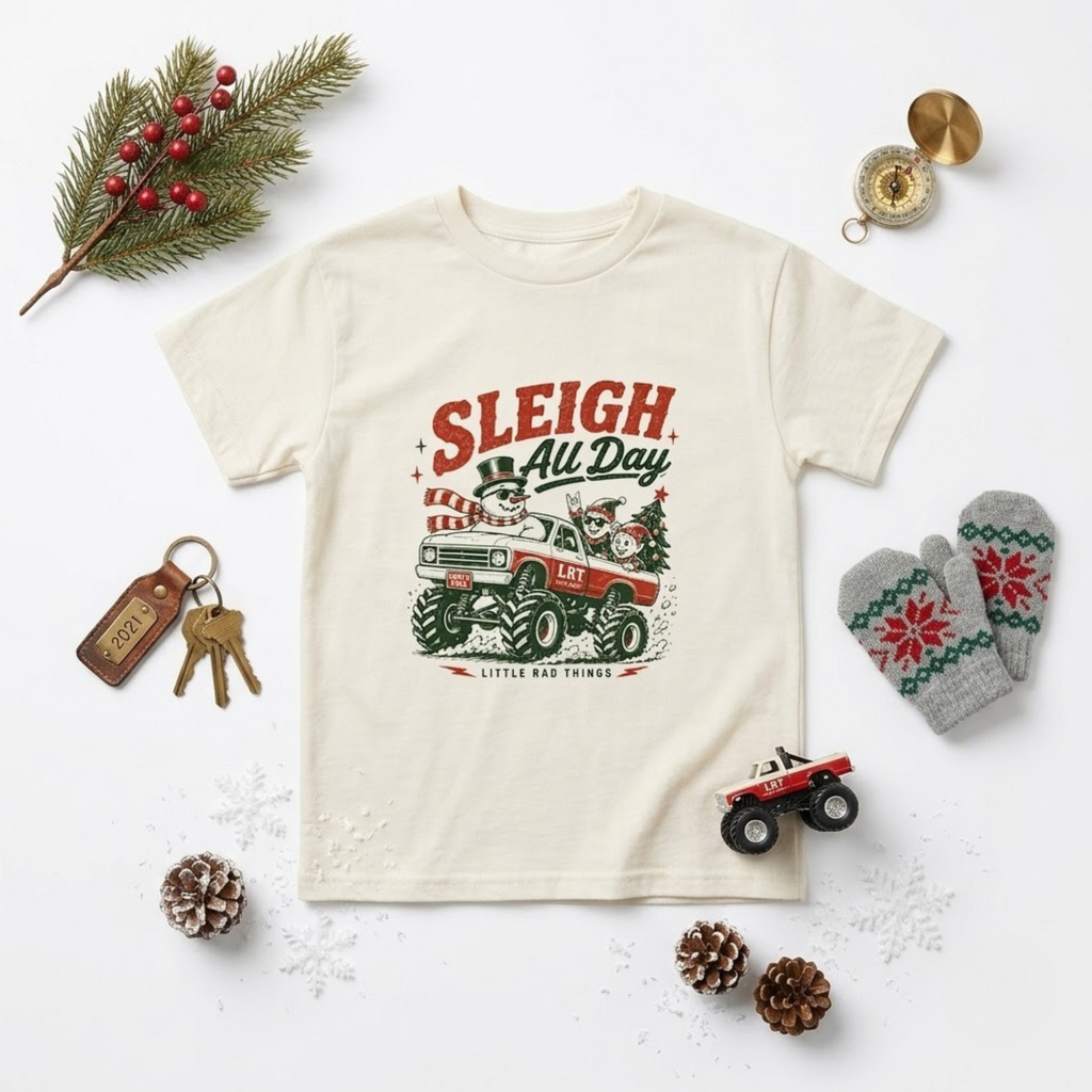 Cream toddler Christmas t-shirt showing “Sleigh All Day” monster truck graphic