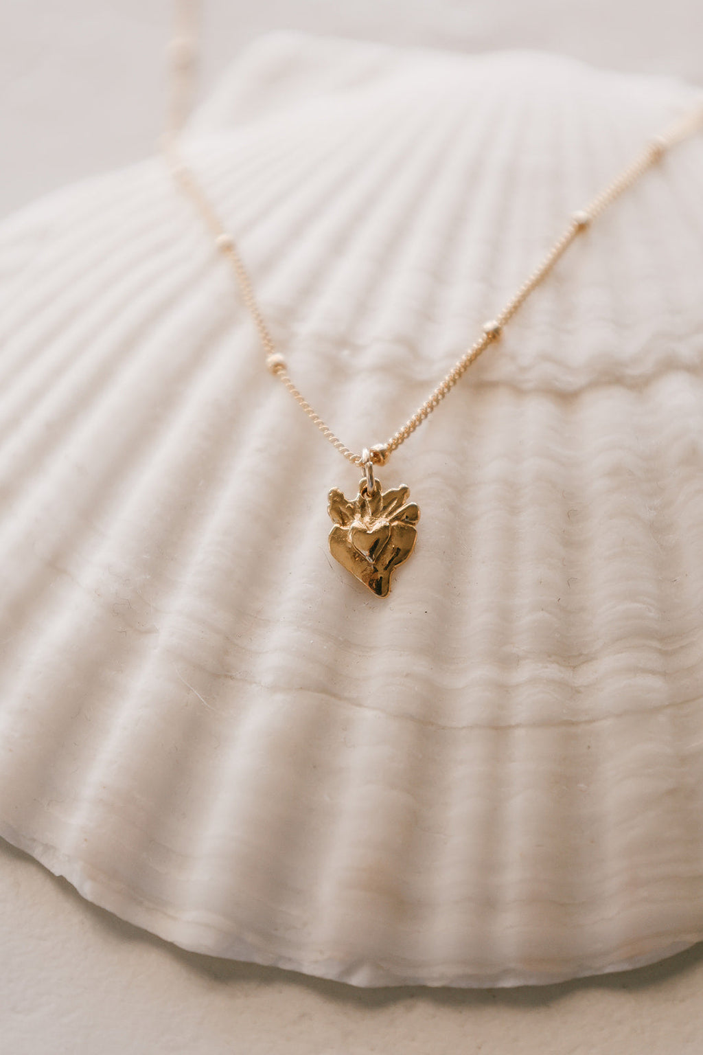 Gold heart charm necklace with tiny sacred heart pendant on a fine chain