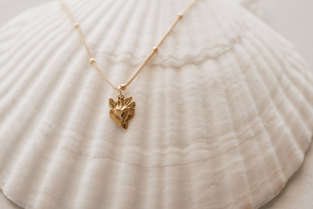 Gold heart charm necklace with tiny sacred heart pendant on a fine chain
