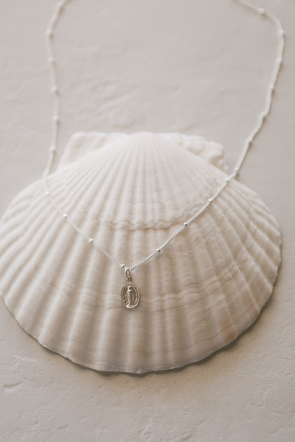 Silver-tone miraculous medal necklace with oval pendant on delicate chain