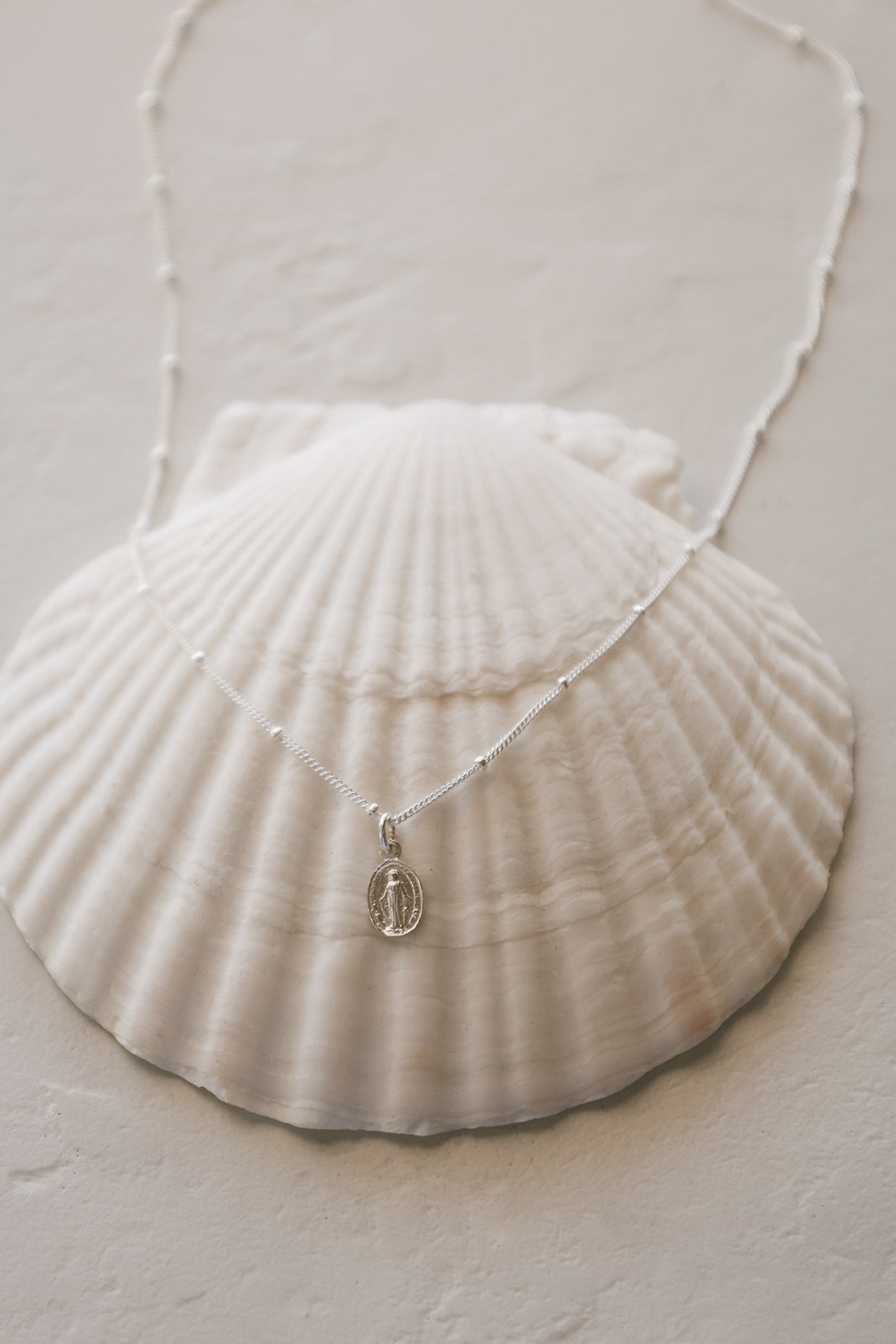 Silver-tone miraculous medal necklace with oval pendant on delicate chain