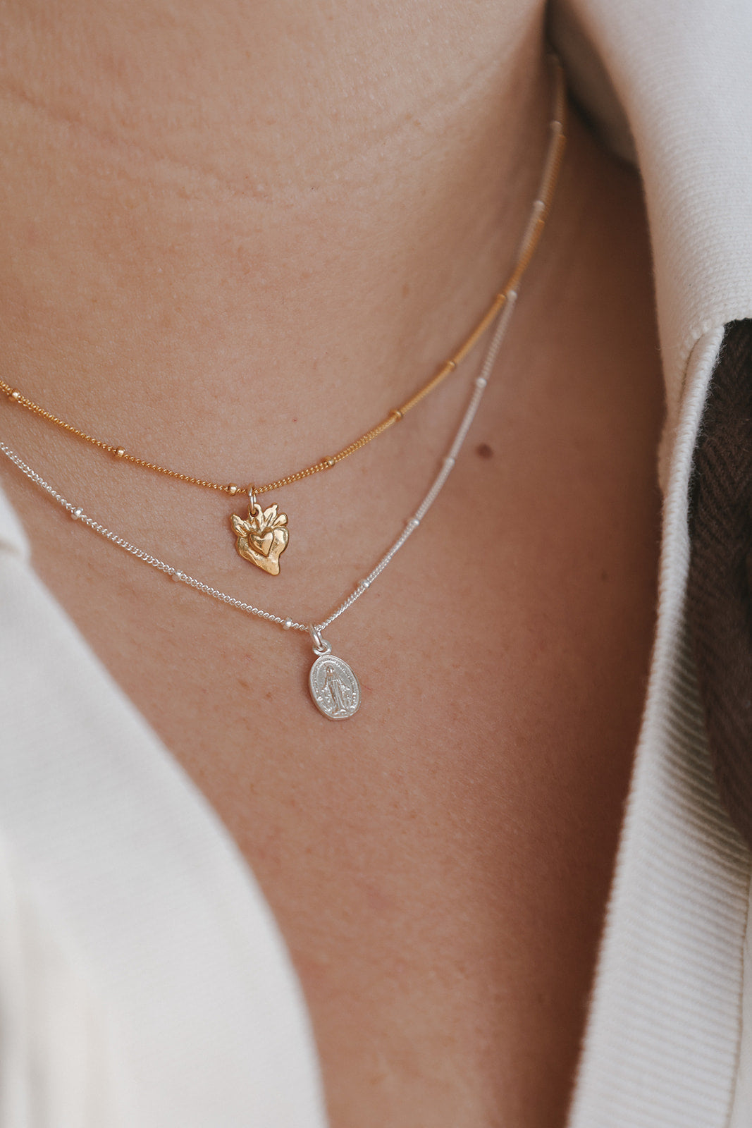 Layered necklaces with sterling silver oval medal charm and gold-tone butterfly charm