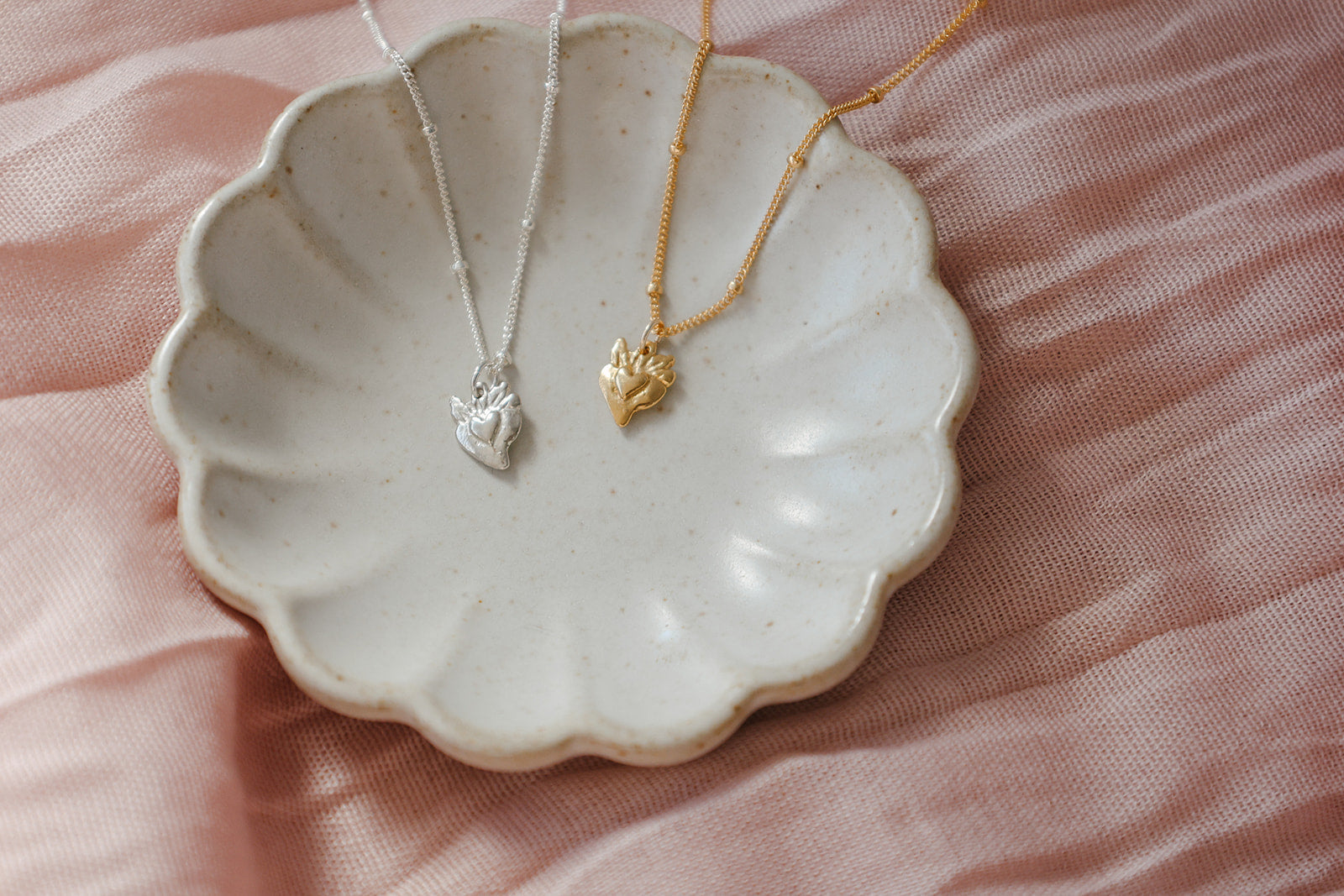 Small heart charm necklaces with gold and silver-tone pendants on fine chains