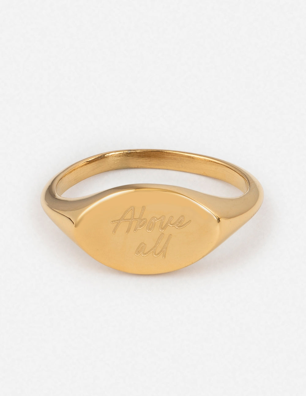 Gold oval signet ring with engraved script on the front