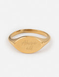 Gold oval signet ring with engraved script on the front