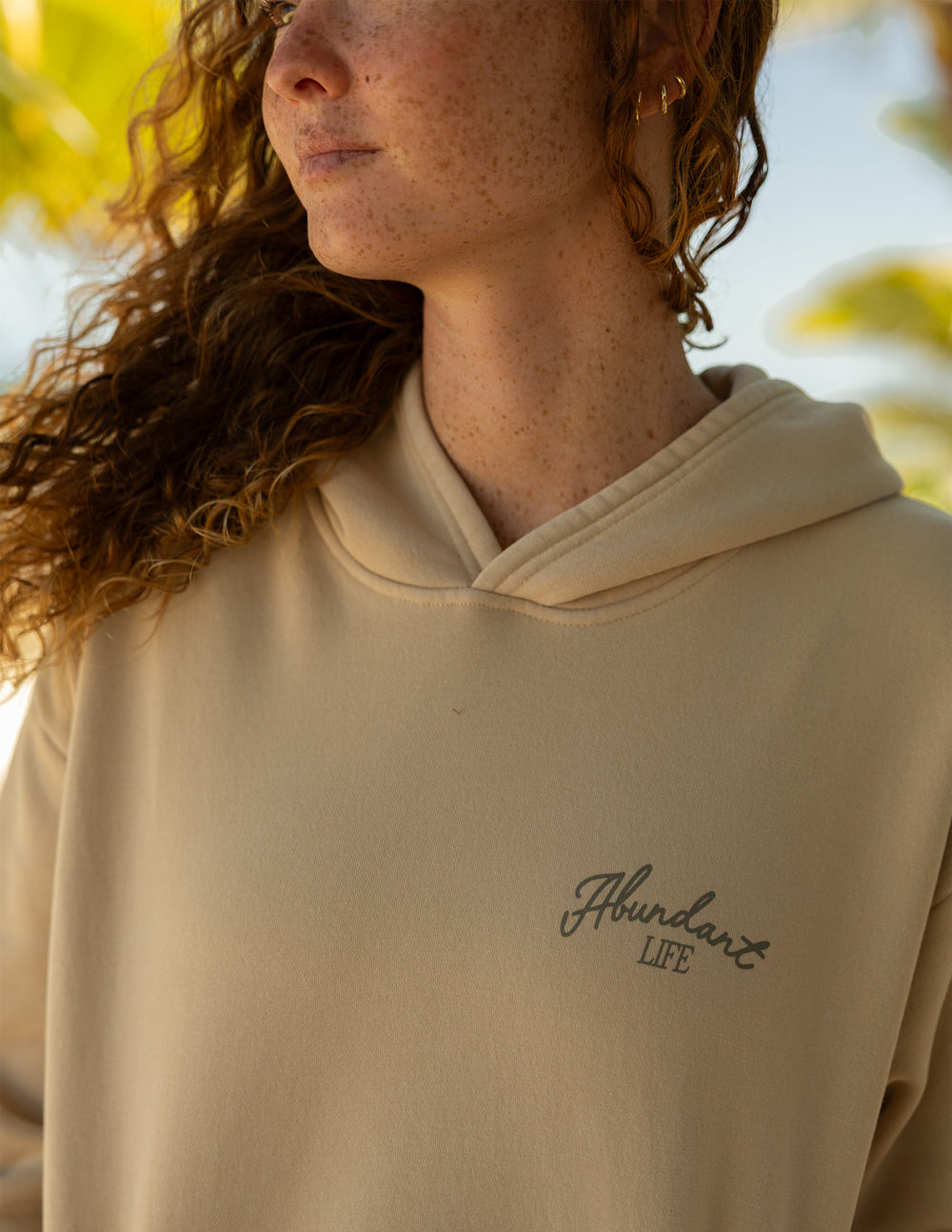 Beige hoodie close-up of hood seam and small chest logo