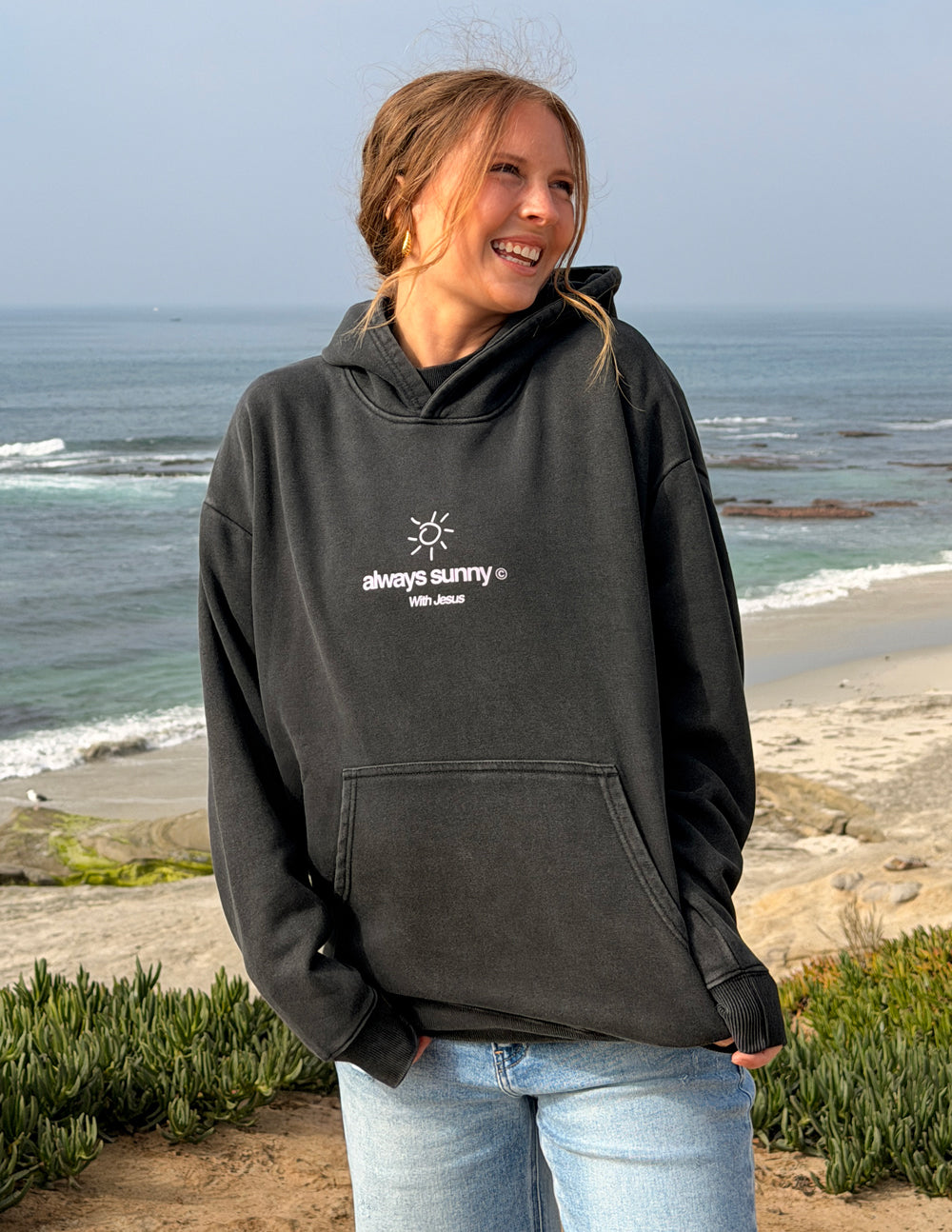Unisex charcoal hoodie with front sun icon and “always sunny” text, hood and pouch pocket