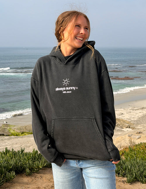 Unisex charcoal hoodie with front sun icon and “always sunny” text, hood and pouch pocket