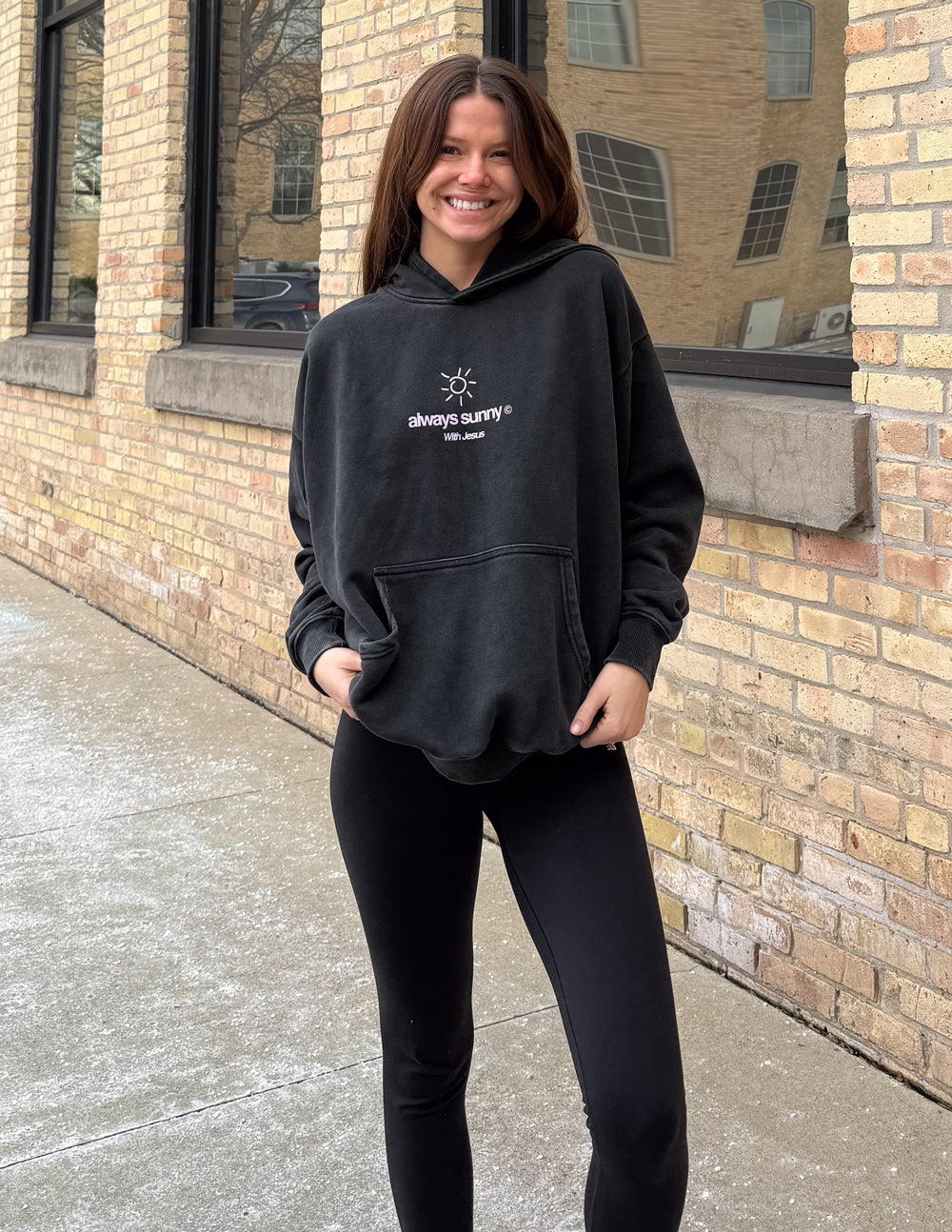 Unisex charcoal hoodie with front sun icon and “always sunny” text, hood and pouch pocket