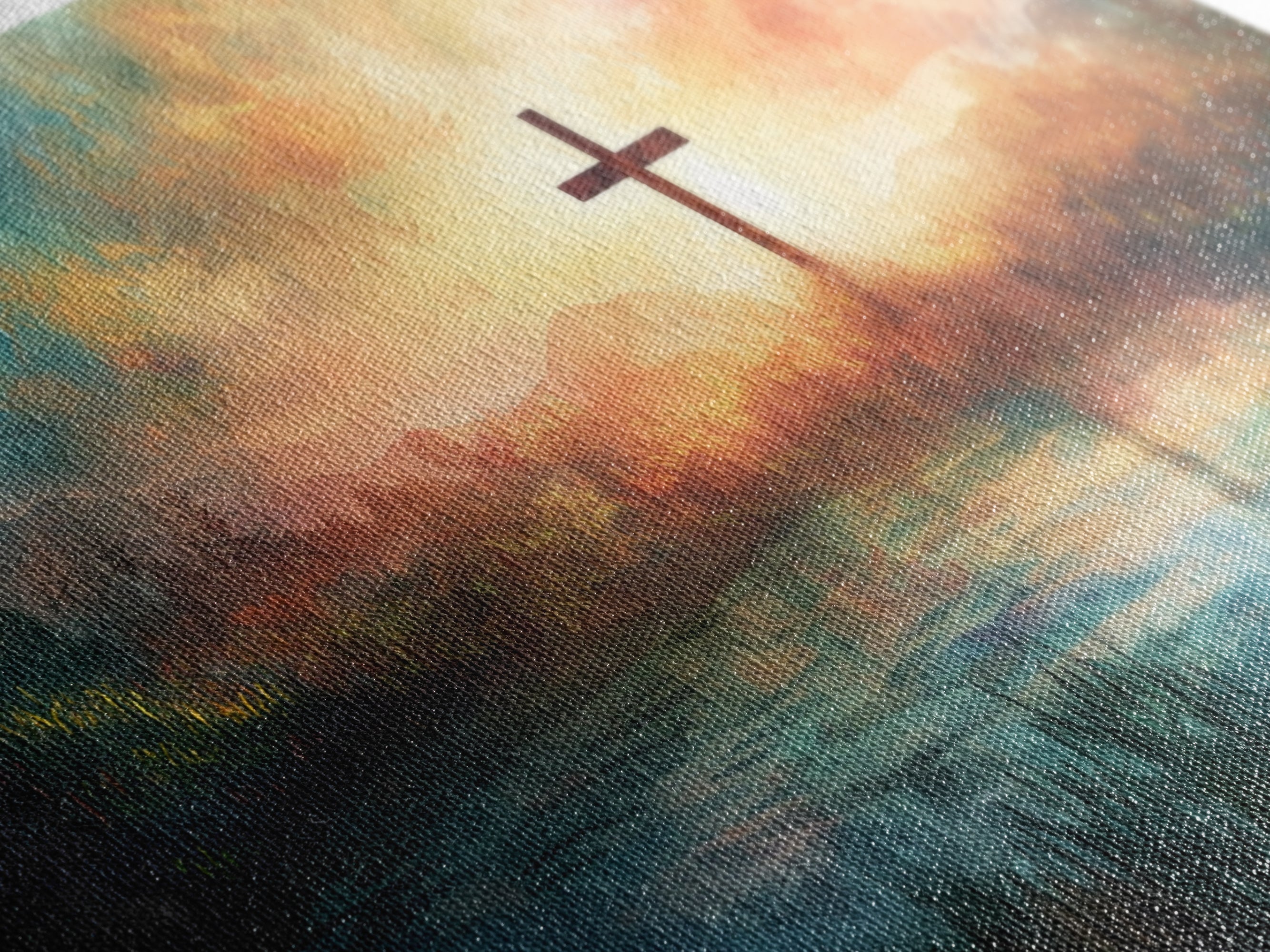 Christian cross on textured canvas with warm sunset clouds and blue-green landscape