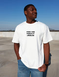 White heavyweight T-shirt with black chest text: Ask Me About Jesus.
