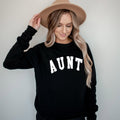 Black crewneck sweatshirt with large white "AUNT" graphic on the front