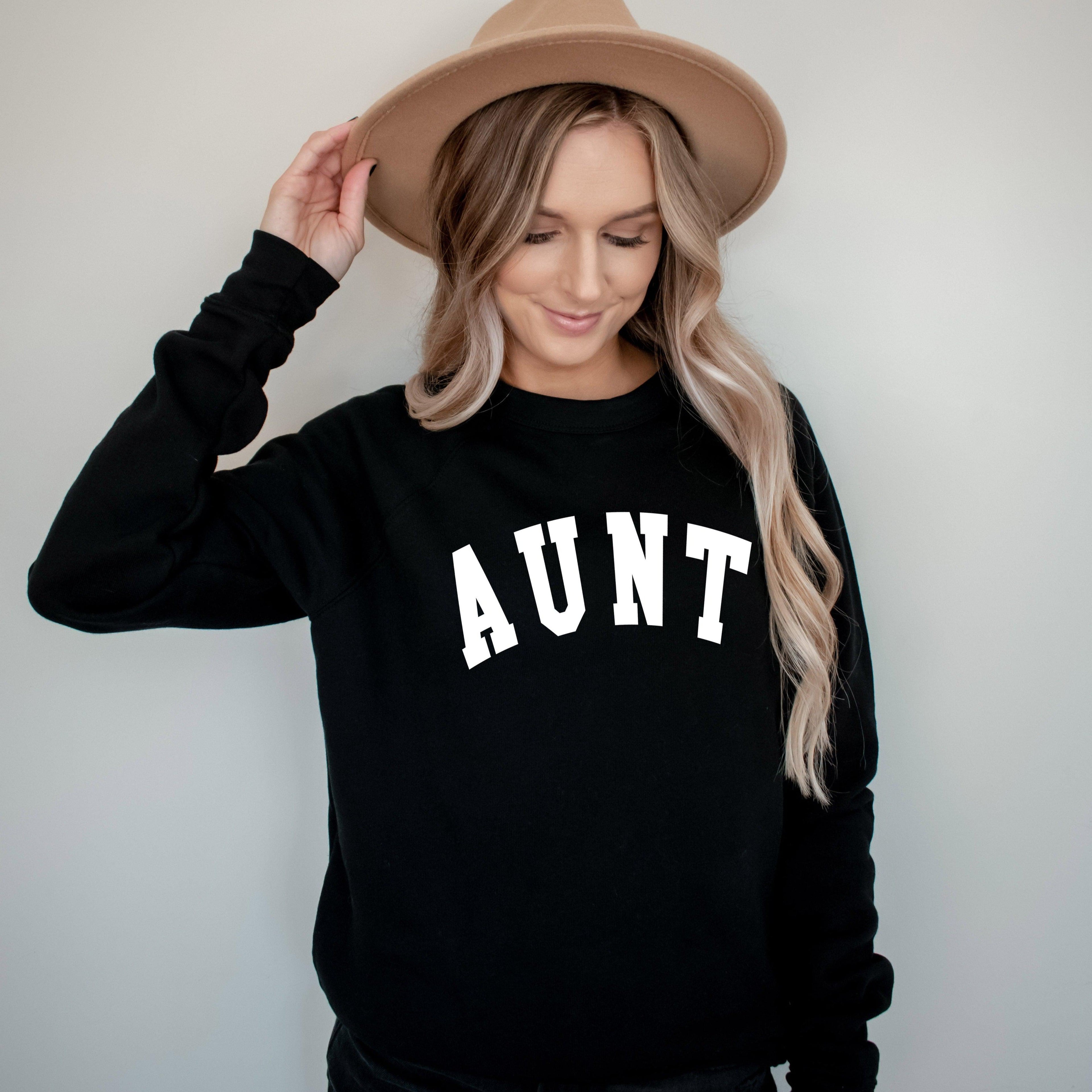 Black crewneck sweatshirt with large white "AUNT" graphic on the front