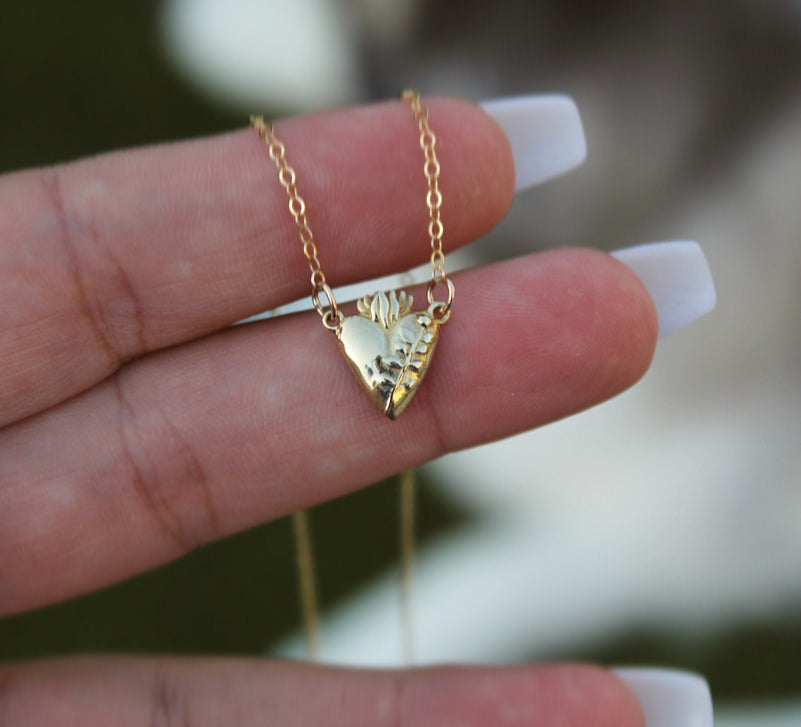 Gold-tone heart pendant necklace with engraved floral accents