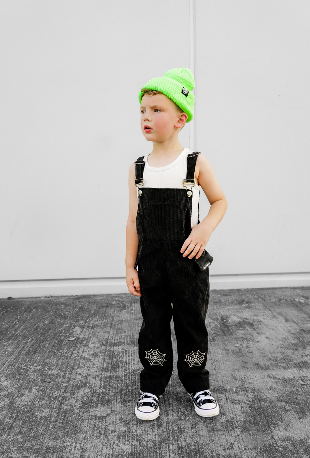 Black spiderweb overalls with adjustable straps, front pocket, and web prints on legs.
