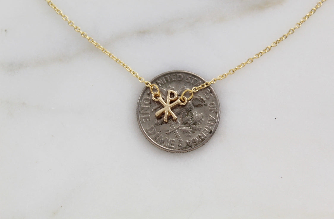 Gold coin-style pendant with Chi Rho emblem on a fine chain