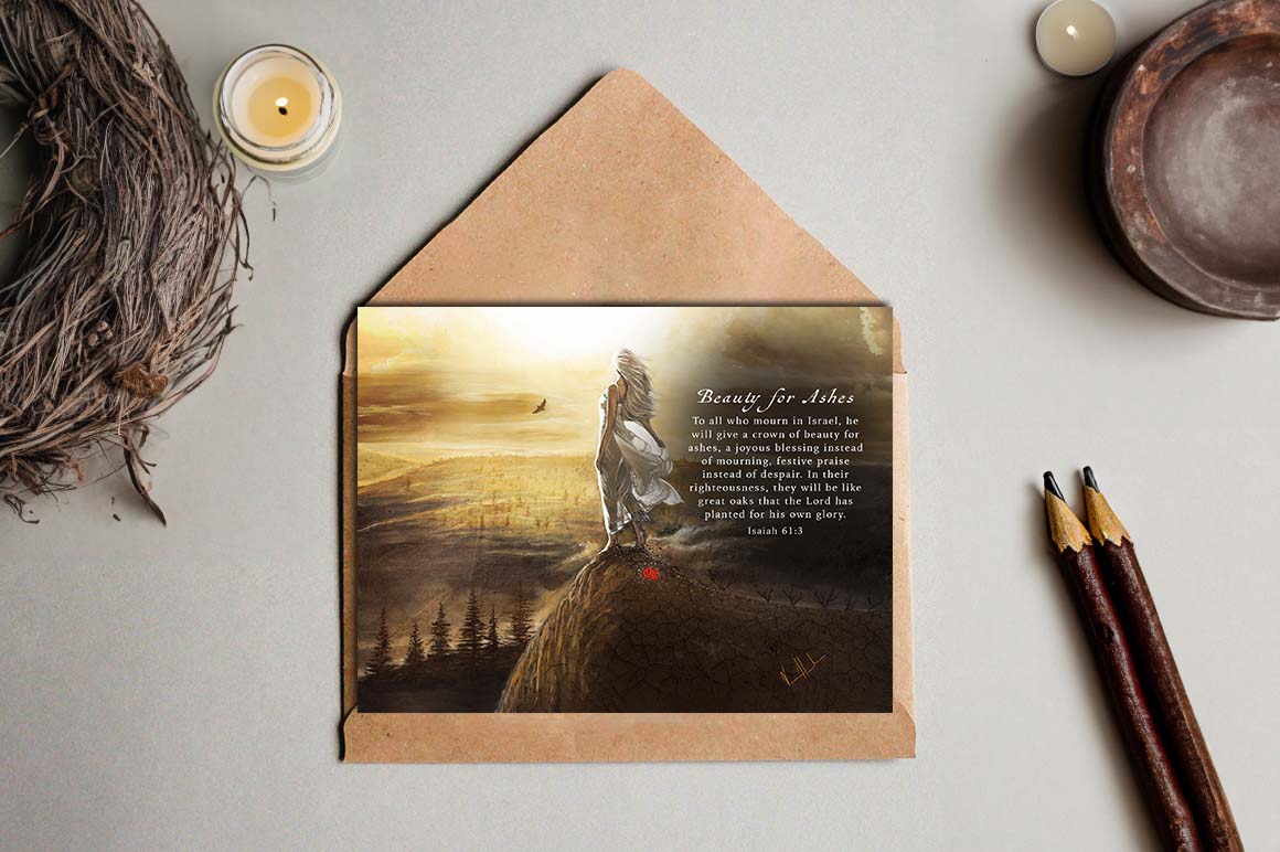 Brown kraft envelope holding 'Beauty for Ashes' greeting card with landscape art